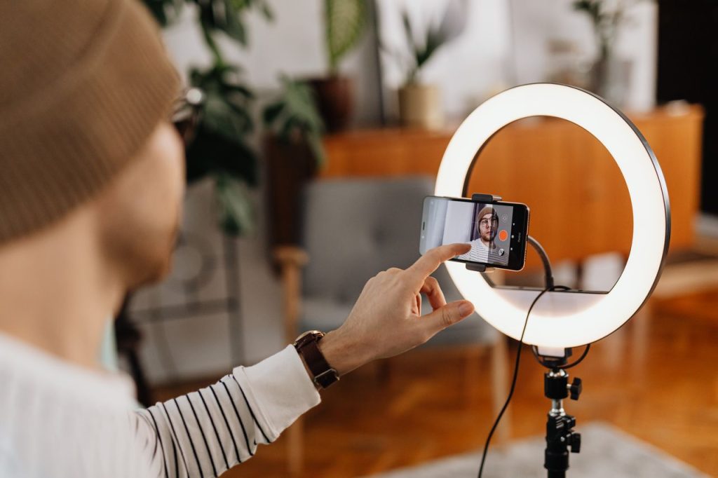 Ring light ile akıllı telefondan video içerik hazırlayan kişi