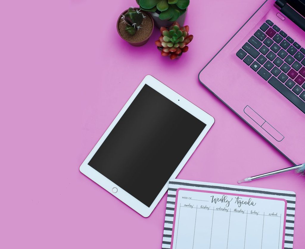 Tablet ve laptop ile pembe temalı dijital planlama masası