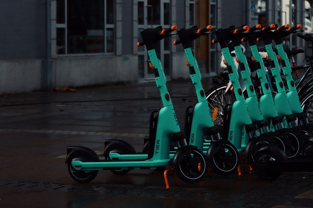 Islak zeminli Jönköping, İsveç'te sıralanmış birden fazla camgöbeği elektrikli scooter.