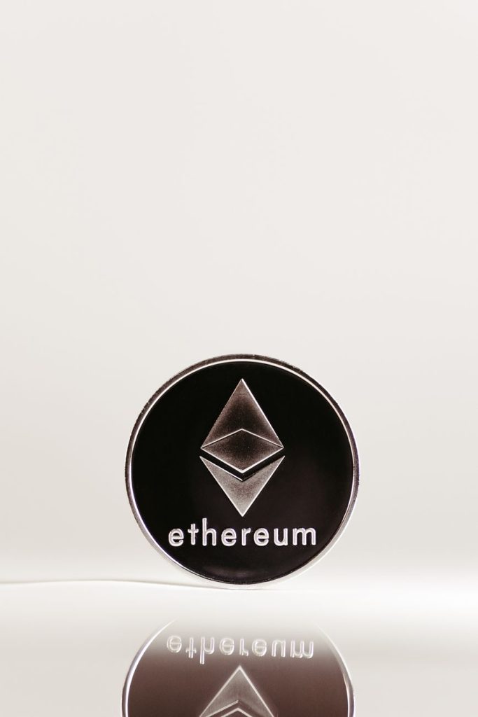 Yansıtıcı bir yüzeyde minimalist tasarıma sahip bir Ethereum kripto para birimi madeni paranın yakın çekimi.