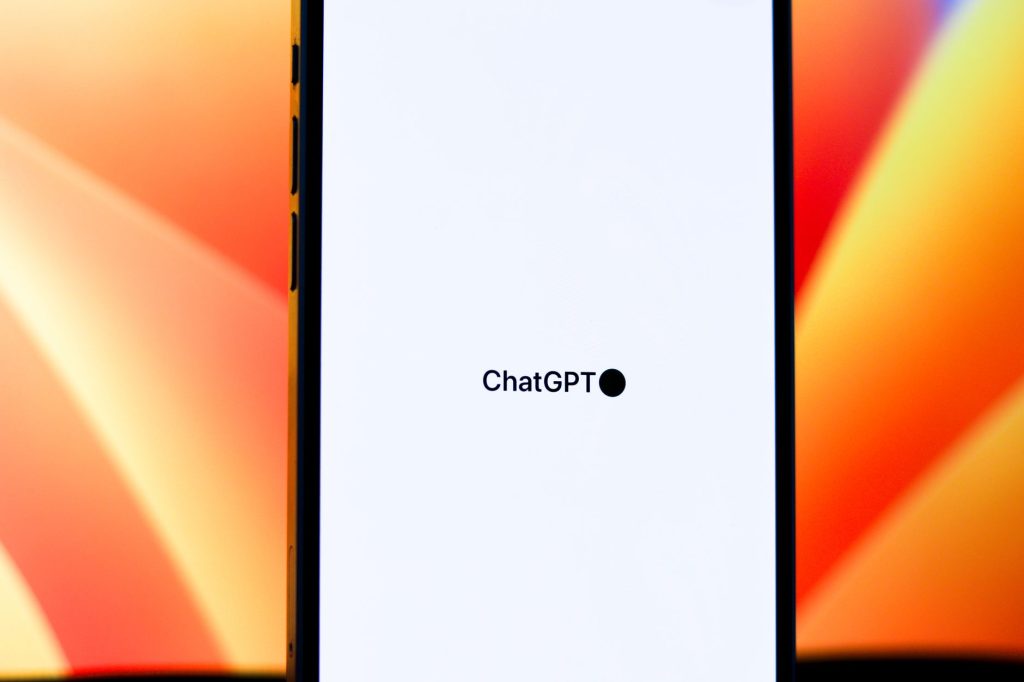 Canlı bir arka planda ChatGPT'yi gösteren bir akıllı telefonun yakın plan görüntüsü. Teknoloji ve yapay zeka temaları için idealdir.