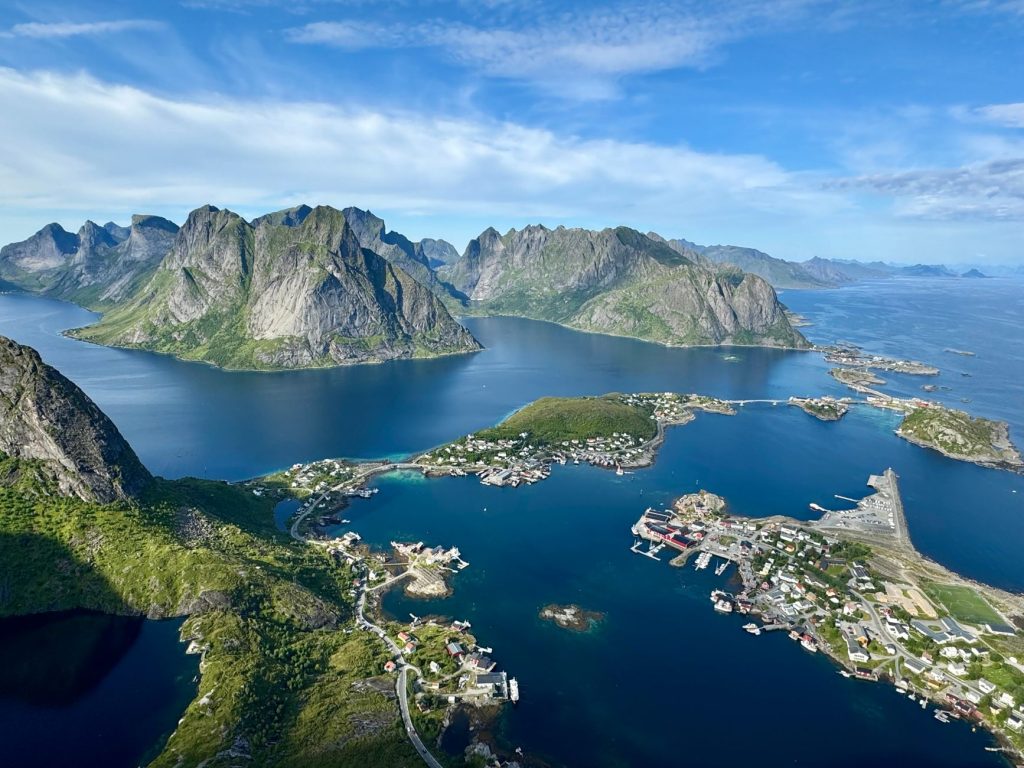 Turkuaz sular ve yeşil adalarla yaz aylarında Norveç fiyortlarının etkileyici havadan görünümü.
