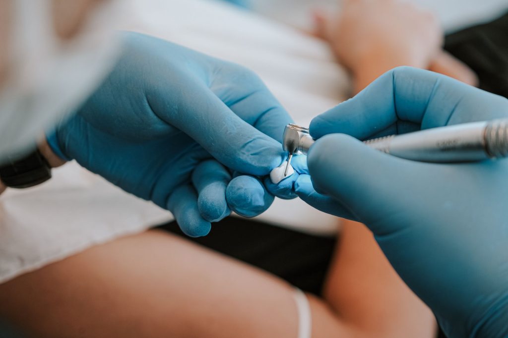 Antalya'daki bir klinikte, sağlık çalışanının ellerinin de yer aldığı, aletlerle yapılan bir diş tedavisinin yakın çekimi.