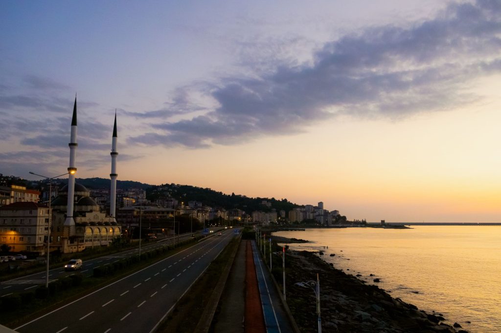Türkiye'nin Rize kentindeki Pazar sahil yolu ve camisi üzerinde huzurlu bir gün batımı manzarası.
