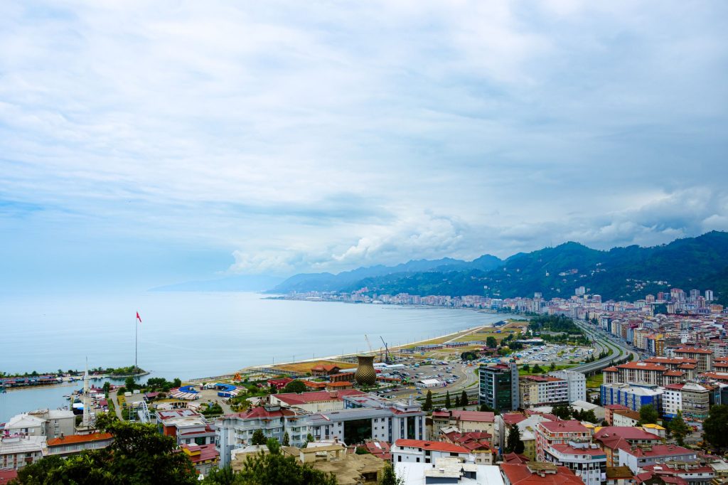 Türkiye'nin Rize şehrinin kıyı manzaraları, dağları ve kentsel mimarisiyle panoramik bir görünümü.