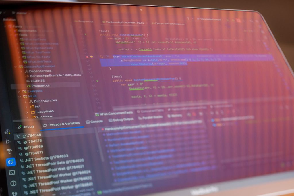 Programlama kodunu gösteren ve görünür yansımaları olan bir bilgisayar ekranının odaklanmış görüntüsü.