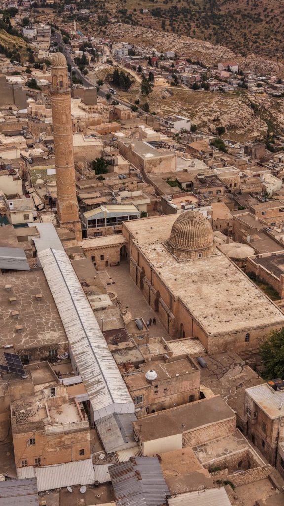 Mardin'in tarihi Ulu Camii'nin çarpıcı bir havadan çekilmiş fotoğrafı, karmaşık mimarisini ve şehir manzarasını sergiliyor.