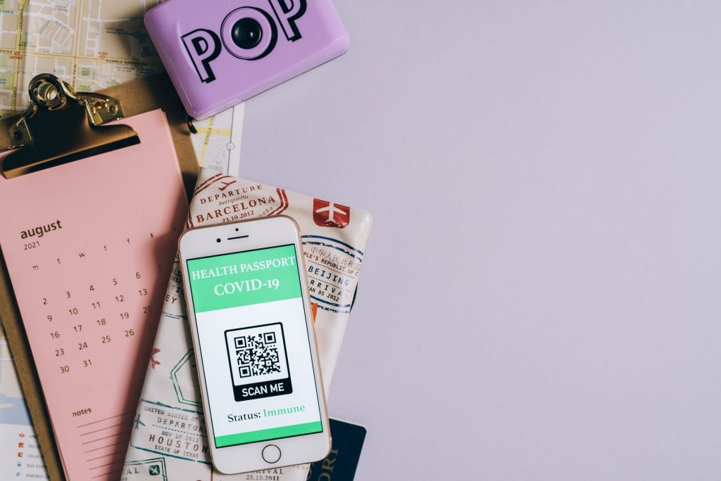 COVID-19 QR kodu, takvim ve harita ile düz yerleştirilmiş sağlık pasaportu görüntüsü.